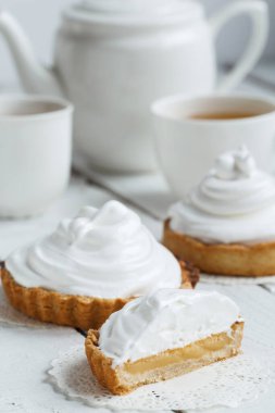 Limonlu ya da kremalı taze limonlu turta ve kağıt üzerinde İtalyan kremalı pasta. Kesilmiş turta. Seçici odak