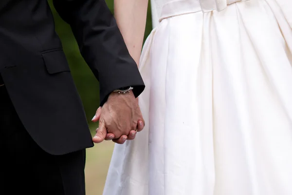 Bride and groom holding hands. — Stock Photo, Image