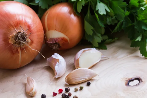 Fresh onion, garlic and parsley on wooden background — Stock Photo, Image
