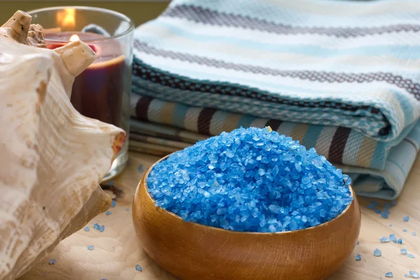 Sea salt in bowl with candle and towels — Stock Photo, Image