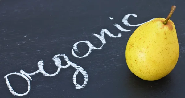 Frische Birne auf Tafel und Bio-Wort von weißer Kreide geschrieben — Stockfoto