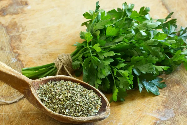 Fresh and dry parsley on wooden background — Stock Photo, Image