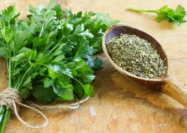 Fresh and dry parsley on wooden background — Stock Photo, Image
