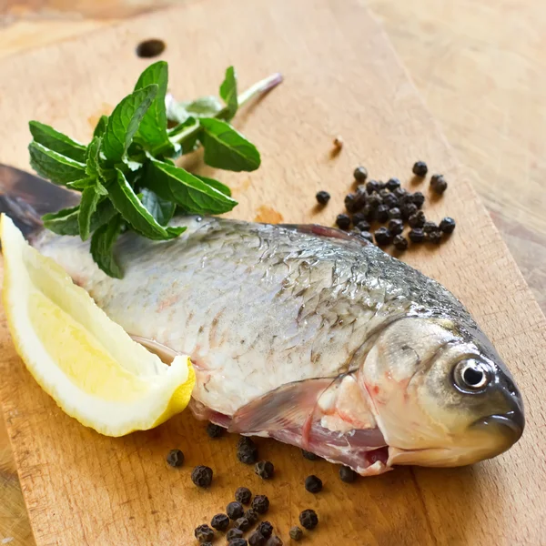 Peixe cru fresco na mesa de madeira — Fotografia de Stock