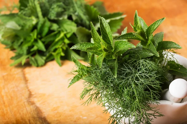 Fresh organic herbs on wooden table — Stock Photo, Image