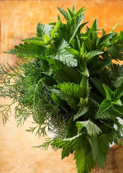 Fresh organic herbs on wooden table — Stock Photo, Image