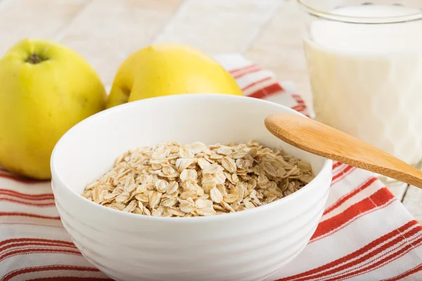 Oat flakes in bowl with apples and milk — Stock Photo, Image