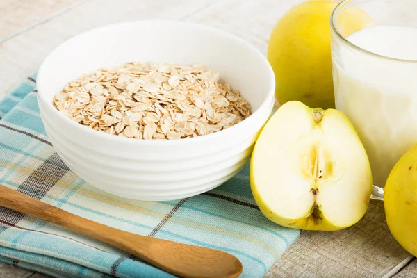 Oat flakes in bowl with apples and milk — Stock Photo, Image