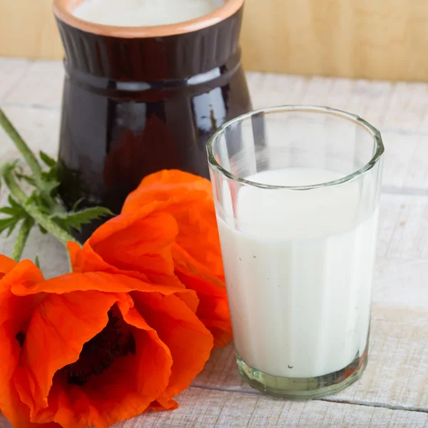 Milch im Glas auf Holztisch — Stockfoto