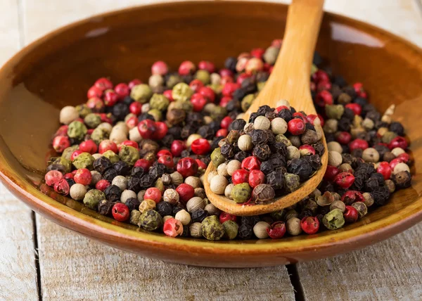 Mixed pepperon plate on wooden background — Stock Photo, Image