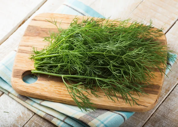 Fresh dill on wooden board — Stock Photo, Image