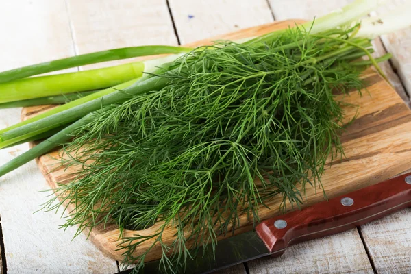 Fresh dill and green onion on wooden board — Stock Photo, Image
