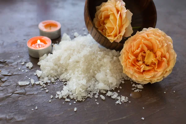 Mořská sůl s rose a svíčky na dřevěné pozadí — Stock fotografie