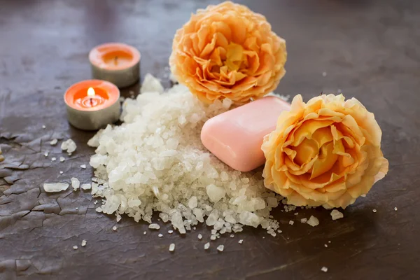 Sal marinho com rosa e velas sobre fundo de madeira — Fotografia de Stock