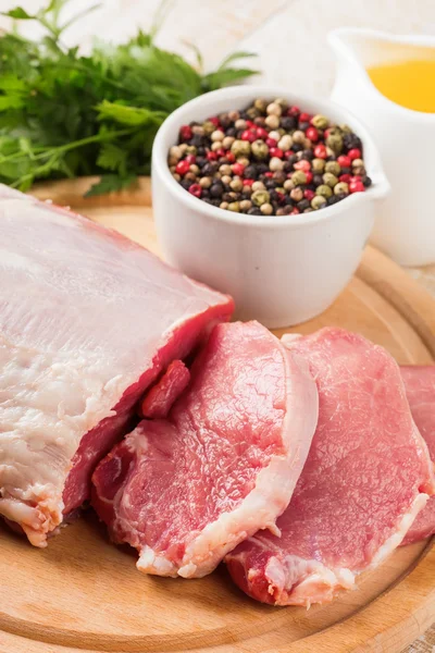 Carne crua fresca no fundo de madeira com pimenta na tigela — Fotografia de Stock