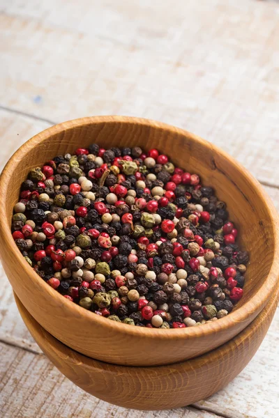 Mixed pepper in wooden can on wooden background — Stock Photo, Image