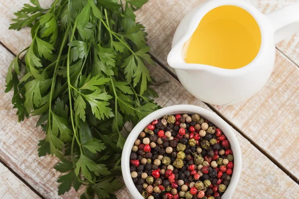 Gemengde peper, olijfolie, zonnebloemolie, kruiden op houten achtergrond — Stockfoto