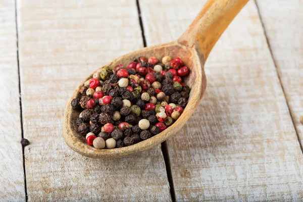 Mixed pepper on wooden background — Stock Photo, Image