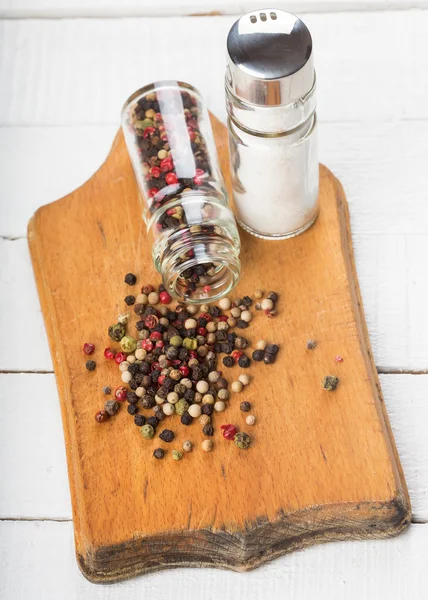 Mixed pepper and salt on wooden board — Stock Photo, Image