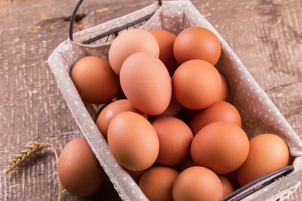 Eggs in bucket on wooden background — Stock Photo, Image