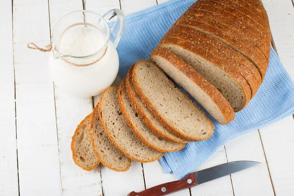 Sliced loaf of bread and milk — Stock Photo, Image