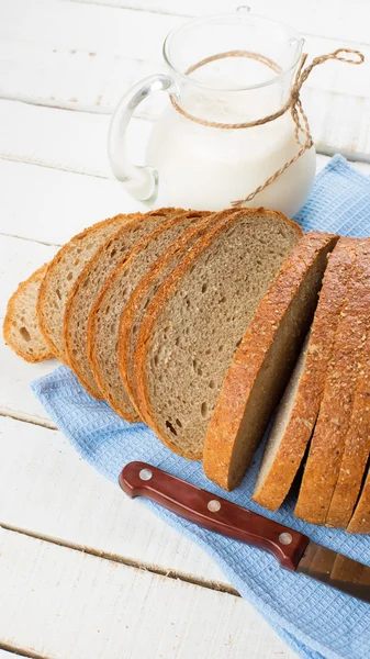 Sliced loaf of bread and milk — Stock Photo, Image