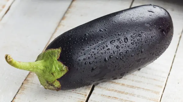 Fresh eggplant on wooden table — Stock Photo, Image