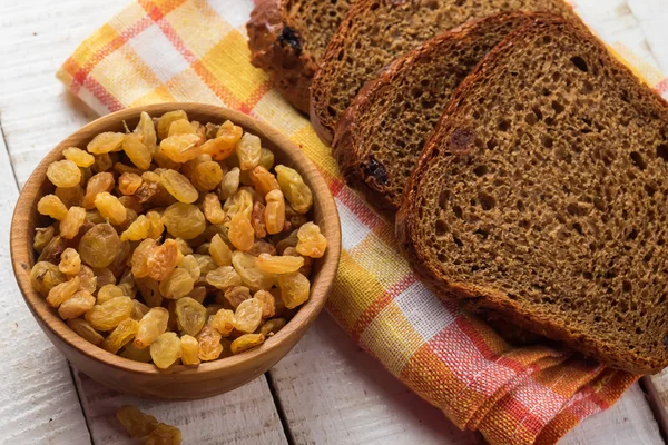 Raisins and bowl and bread — Stock Photo, Image