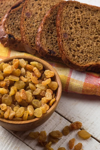Rozijnen en kom en brood — Stockfoto