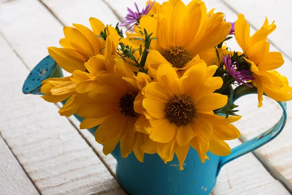 Flores frescas amarelas em regar pode — Fotografia de Stock