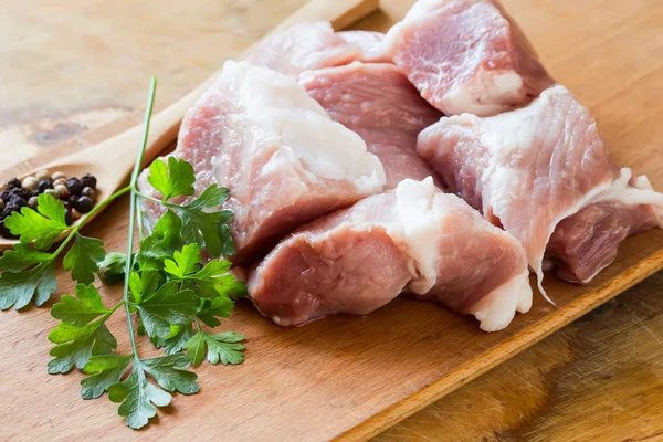 Carne crua fresca no fundo de madeira com pimenta na colher — Fotografia de Stock