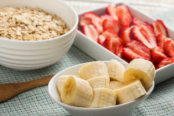 Plátano, fresas, copos de avena en un tazón — Foto de Stock