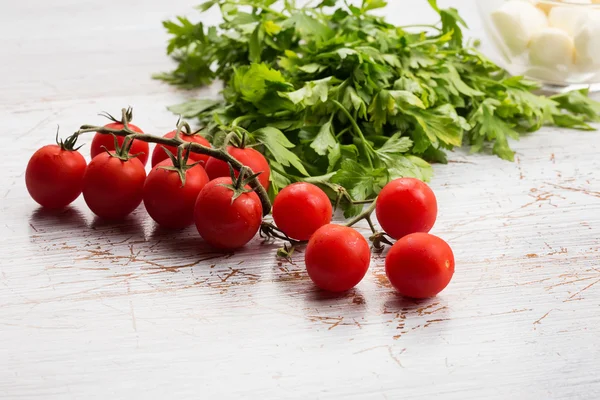 Fresh tomatoes and herbs on wooden table — Stock Photo, Image