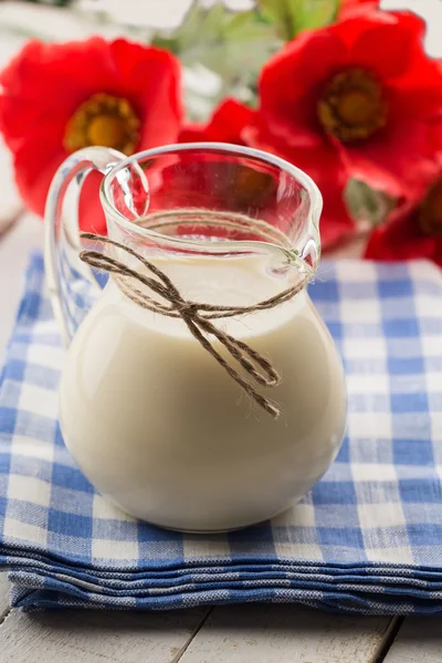 Leche en jarra sobre mesa de madera — Foto de Stock