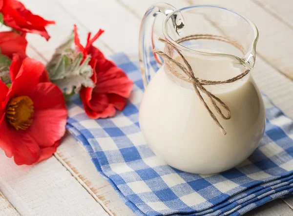 Milch im Krug auf Holztisch — Stockfoto