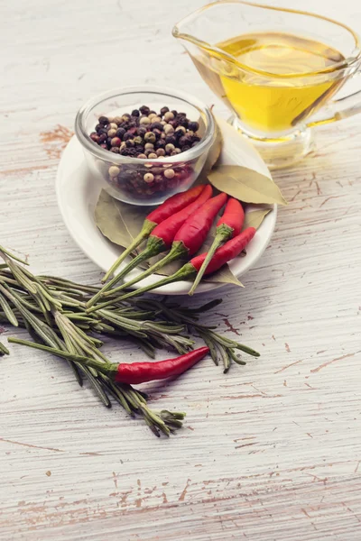 Chili peper, rozemarijn, peper, laurier, olie — Stockfoto