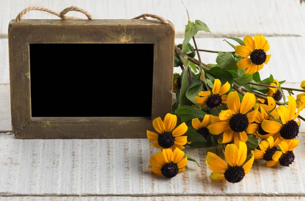 Podzimní květiny na stole s prázdnou tabuli — Stock fotografie