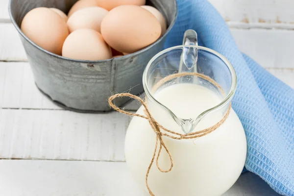 Milk in pitcher on wooden table