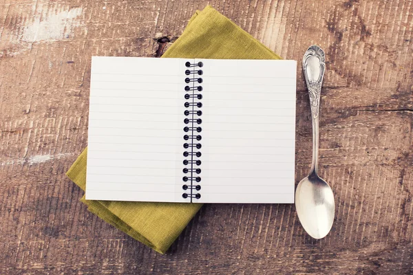 Open empty notebook with spoon — Stock Photo, Image