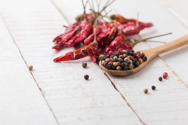 Poivre mélangé et chili sur fond de bois — Photo