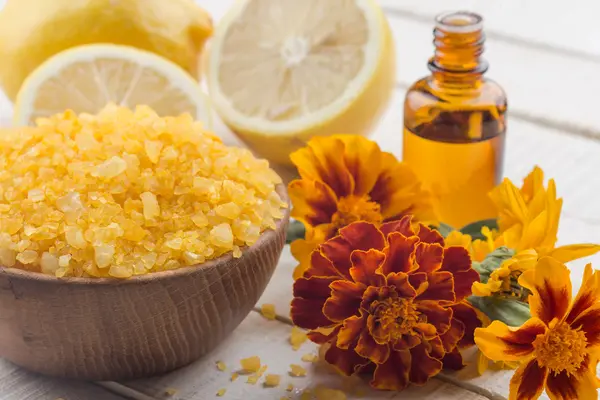 Sea salt in bowl with lemons,aroma oil and marigold — Stock Photo, Image