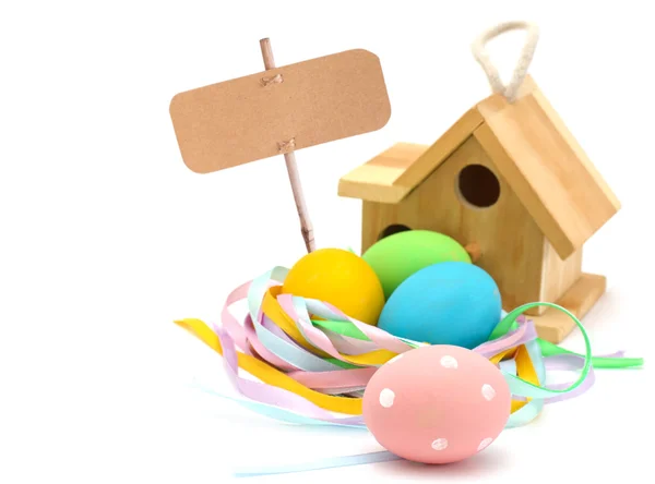 Easter eggs   and bird house  with empty tag — Stock Photo, Image