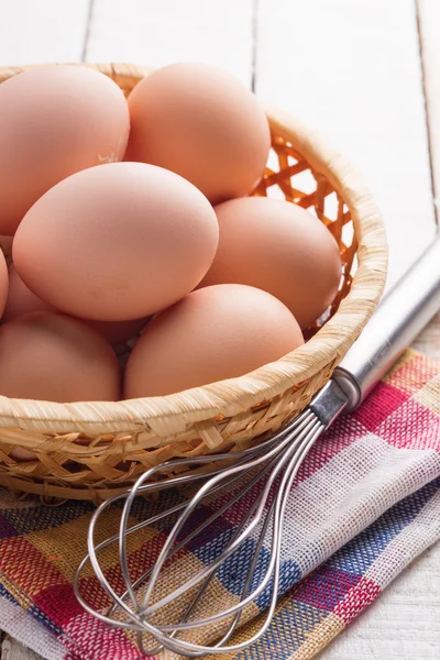 Куриные яйца в миске на деревянном фоне — стоковое фото