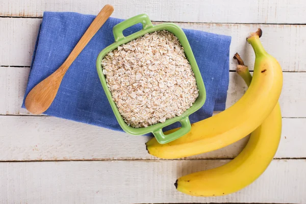 Oat flakes in bowl with banana — Stock Photo, Image