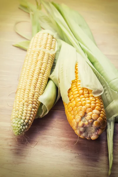 Čerstvé kukuřice na dřevěném pozadí — Stock fotografie
