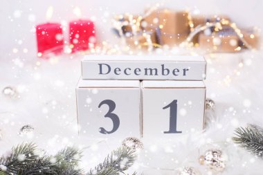 Yılbaşı takvimi, köknar ağacı dalları, kırmızı mumlar, hediyeli kutular. Seçici odaklanma. Metin için yer.