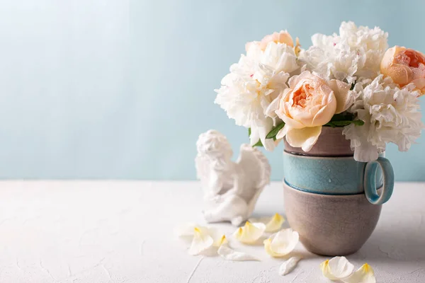 花瓶の青を背景にロマンチックな夏のバラや牡丹の花や天使とポストカード 選択的フォーカス まだ生きてる テキストの場所 — ストック写真