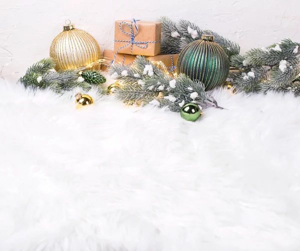 Goldene Kugeln Verpackte Geschenke Tannenzweige Und Lichterketten Auf Weißem Fellhintergrund — Stockfoto