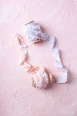 Açık mavi ve pembe ipek kurdeleler desenli pembe arka planda. Durgun hayat. Düz yatıyordu. Düğün için. Romantik kartpostal.