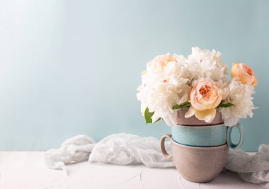 İçinde renkli yaz gülleri ve şakayık çiçekleri olan omantik kartpostal vazonun mavi arka planına karşı. Seçici odaklanma. Mesaj için yer. Durgun hayat. 